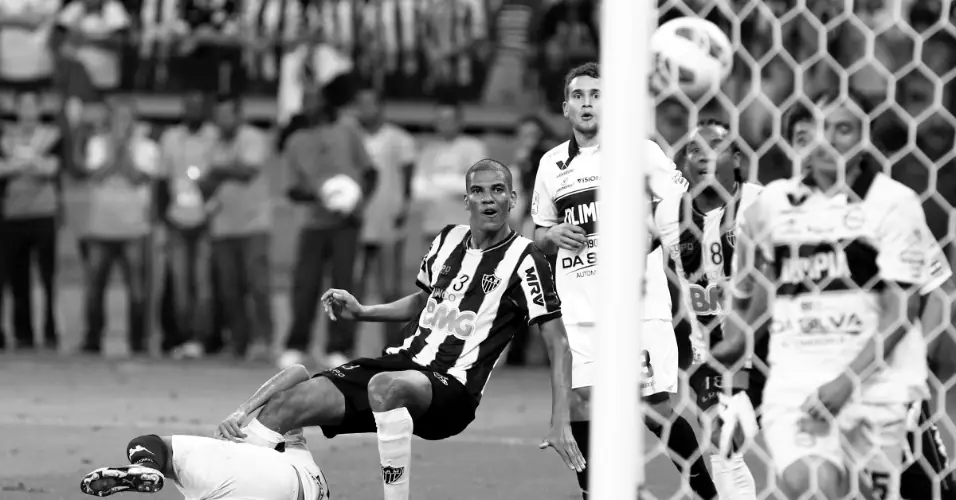 Leonardo Silva, caído no gramado, vê a bola entrar no gol do Olimpia